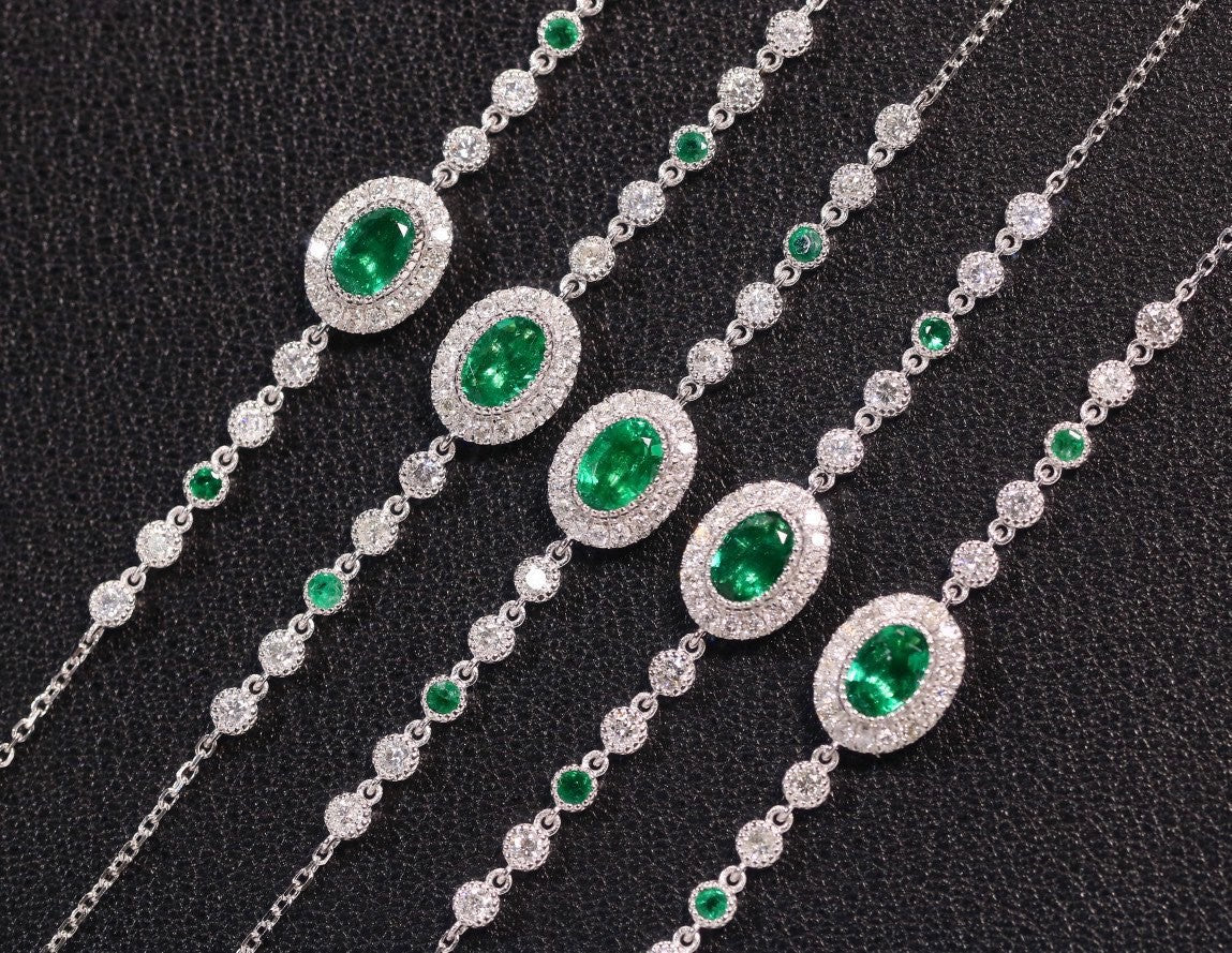 Silver necklaces with green gemstones on a black background