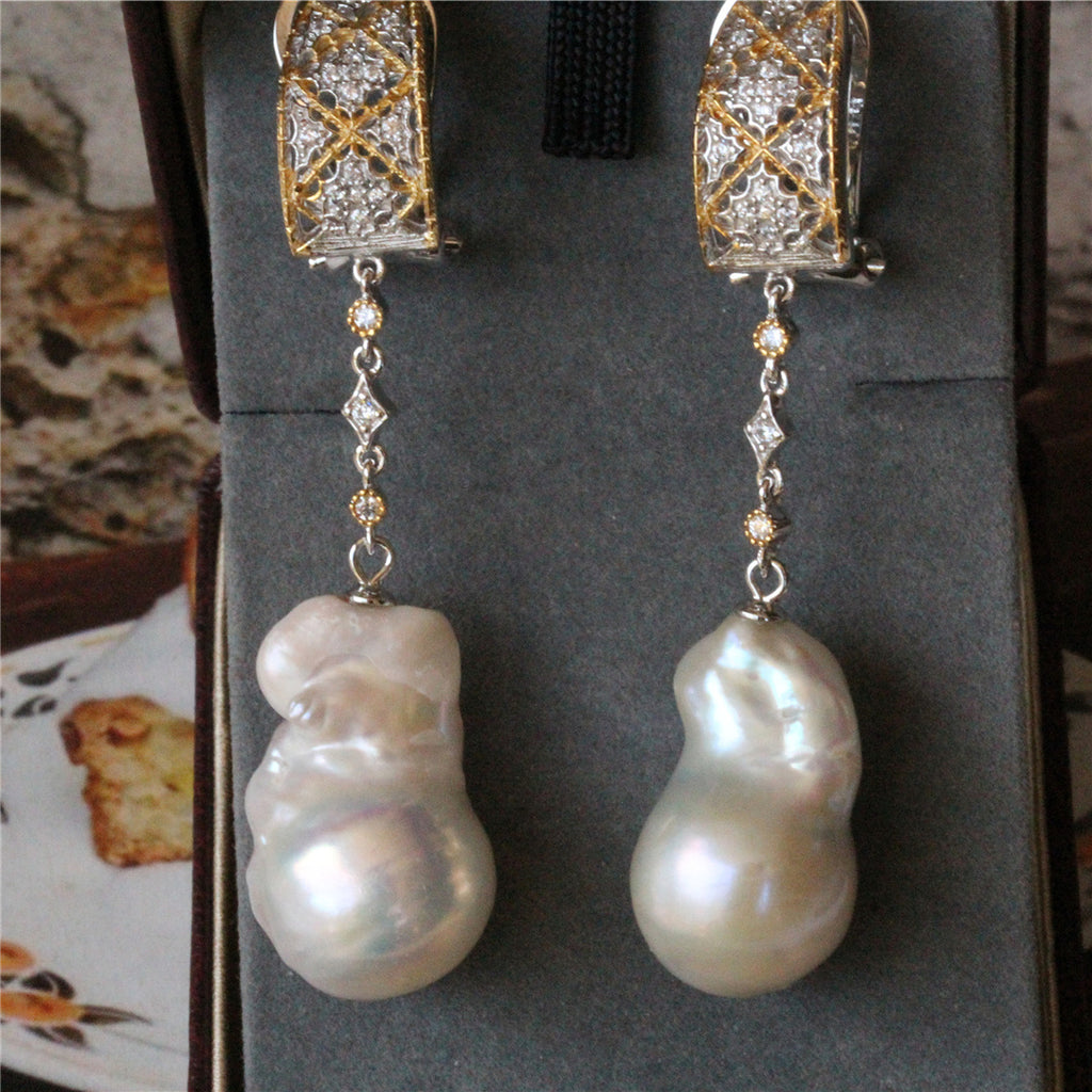 Pearl earrings with gold and diamond accents on a gray background