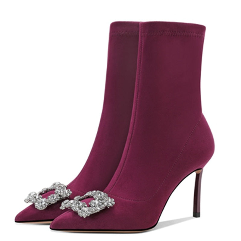 Purple high-heeled boots with decorative buckles on a white background