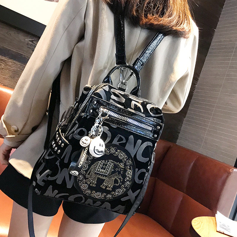 Person wearing a black backpack with decorative elements in an indoor setting