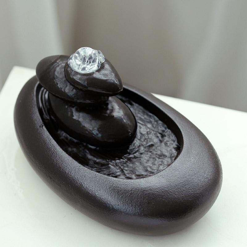 Black stone-like water fountain with a clear crystal on top