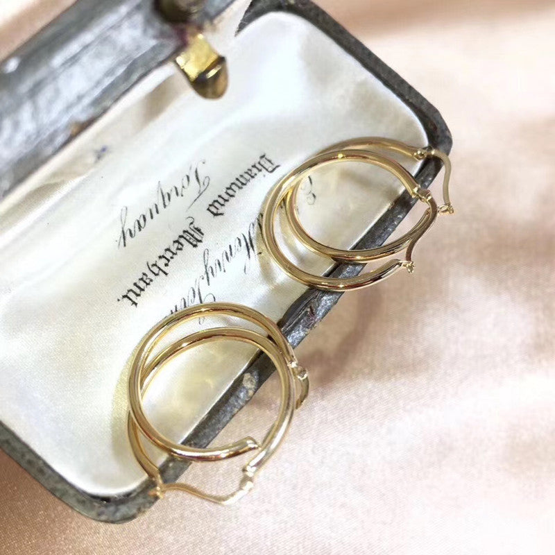 Gold hoop earrings in a jewelry box with 'Hobbs' engraving.