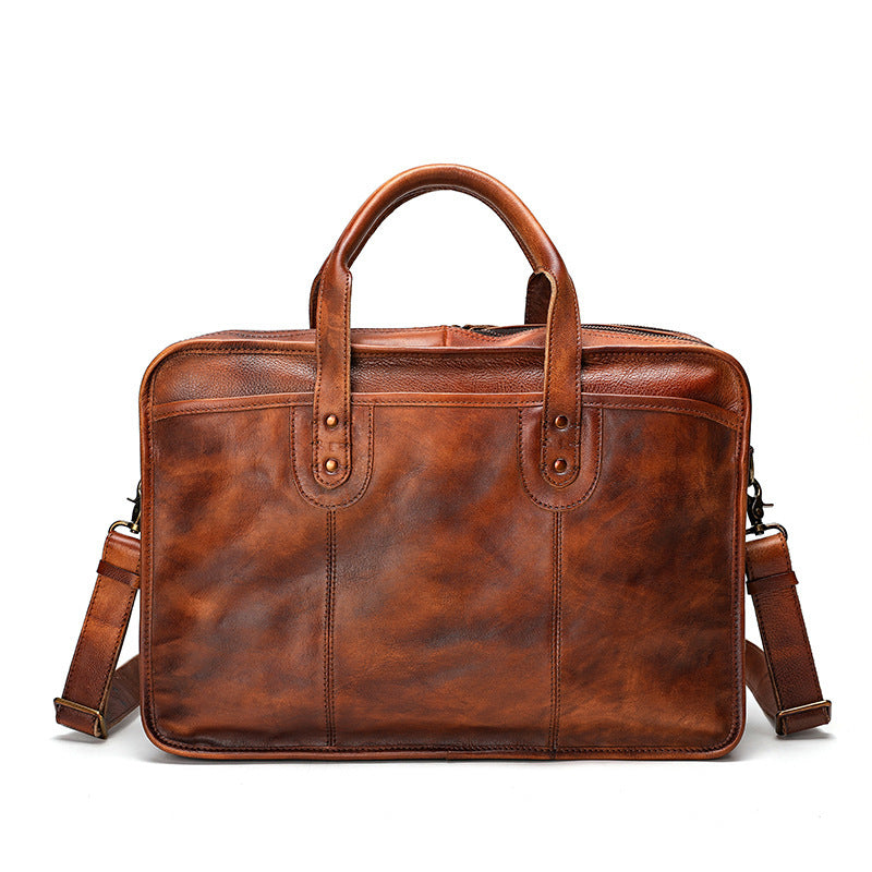 Brown leather briefcase with shoulder strap on a white background