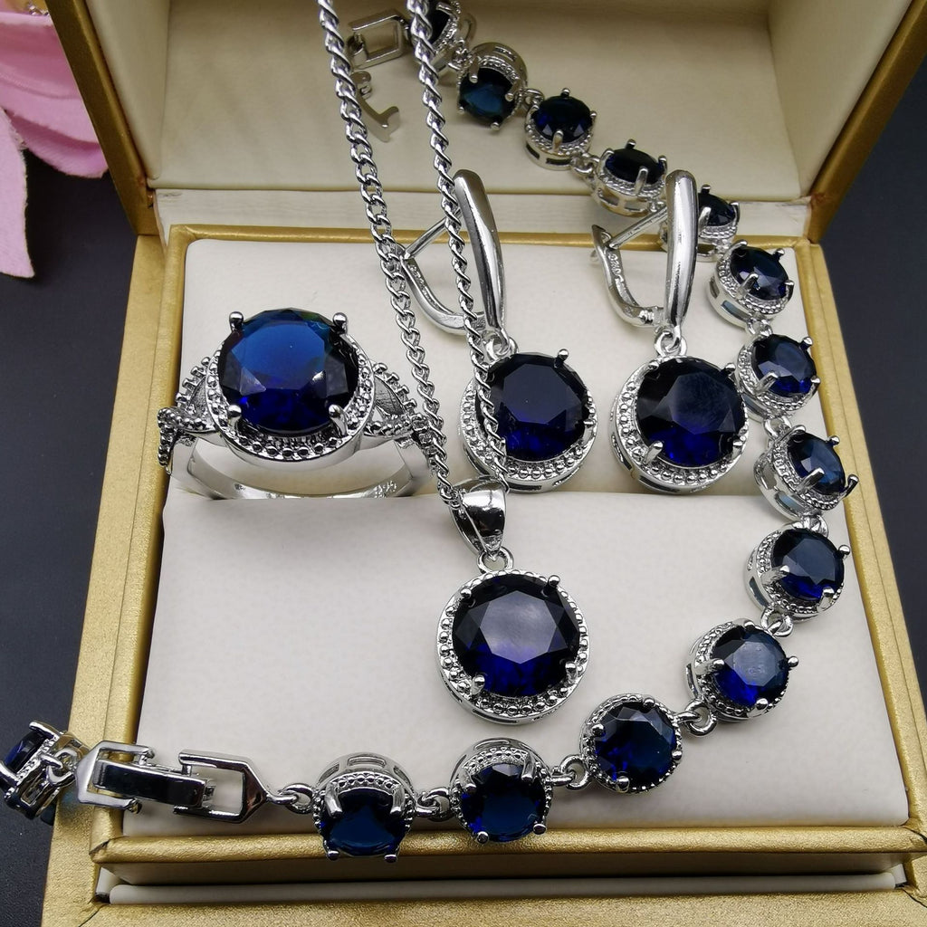 Jewelry set with blue gemstones and silver accents displayed in an open jewelry box.