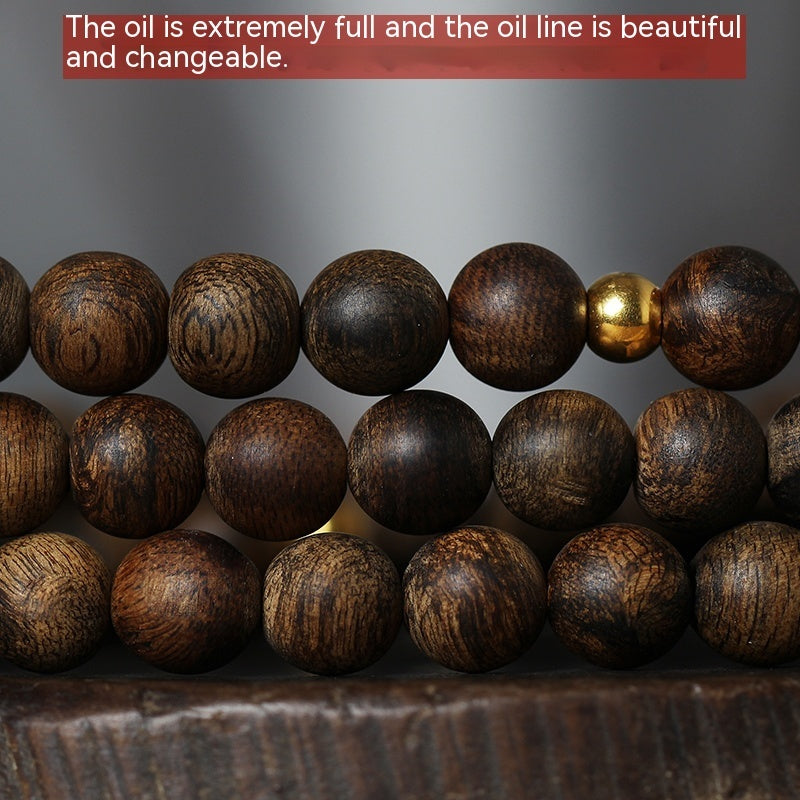 Wooden beads with a gold accent on a dark surface
