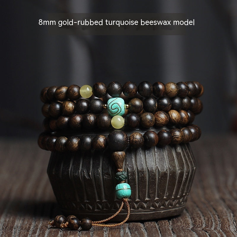 Stack of wooden beaded bracelets with turquoise beads on a dark background