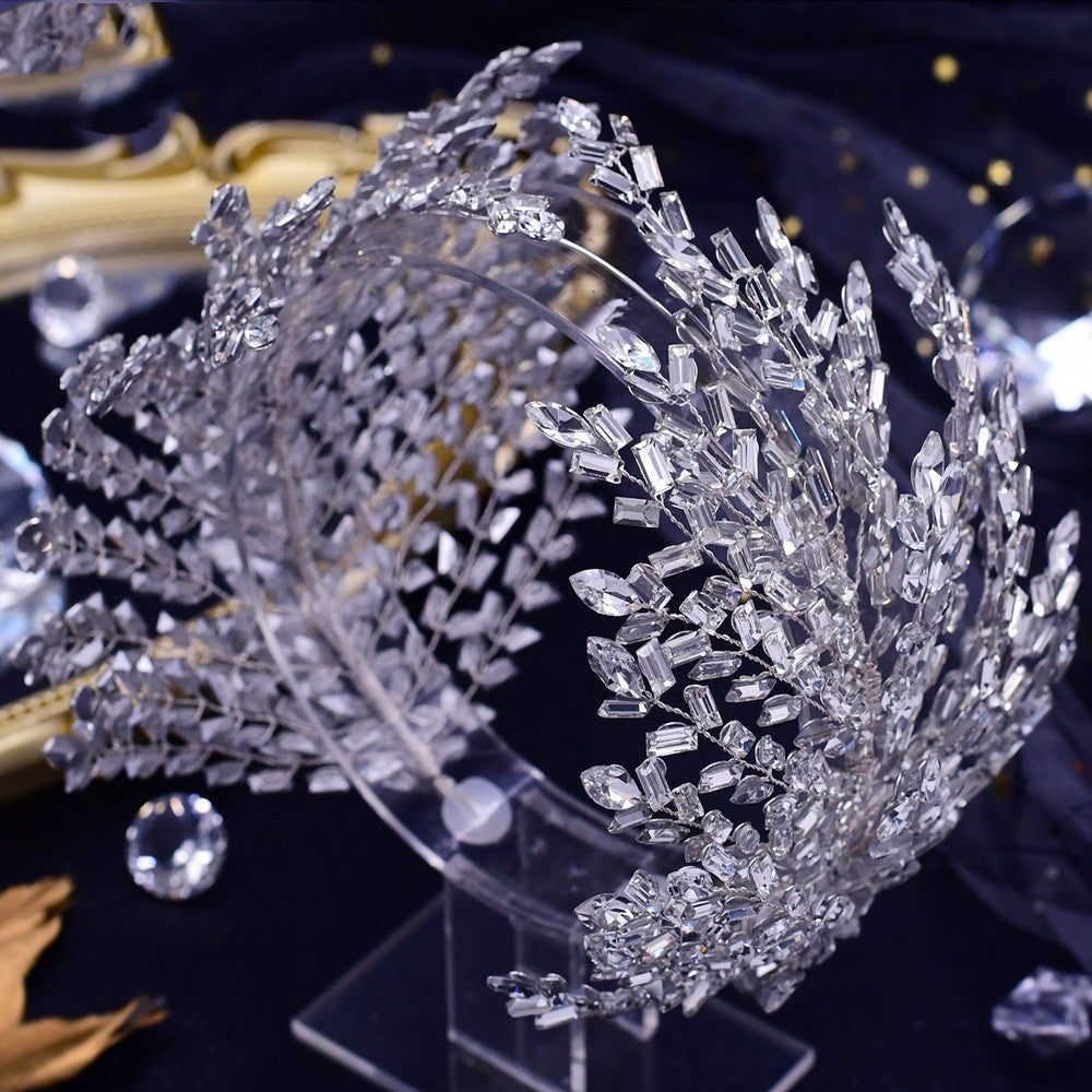 Silver tiara with crystal embellishments on a dark background