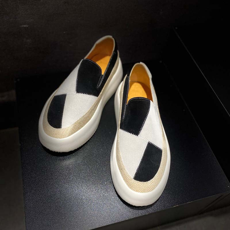 Pair of black and white checkered loafers on a dark surface