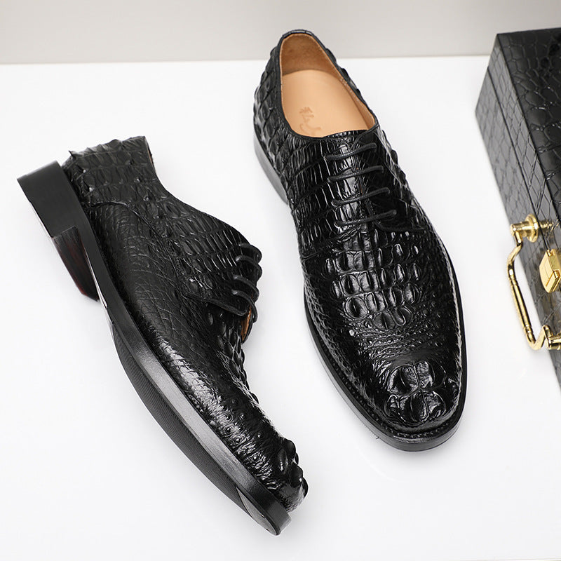 Black crocodile-patterned shoes on a white background with a black box.