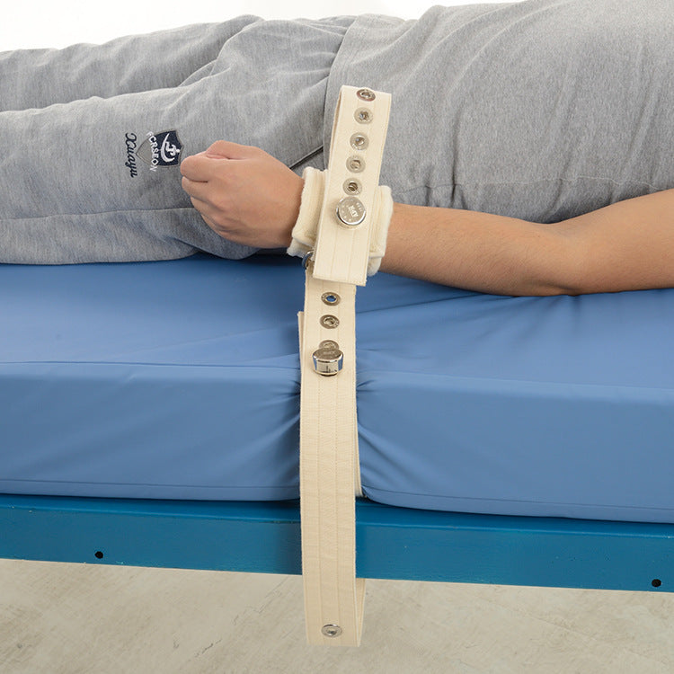 Person lying on a bed with a medical device attached to their arm
