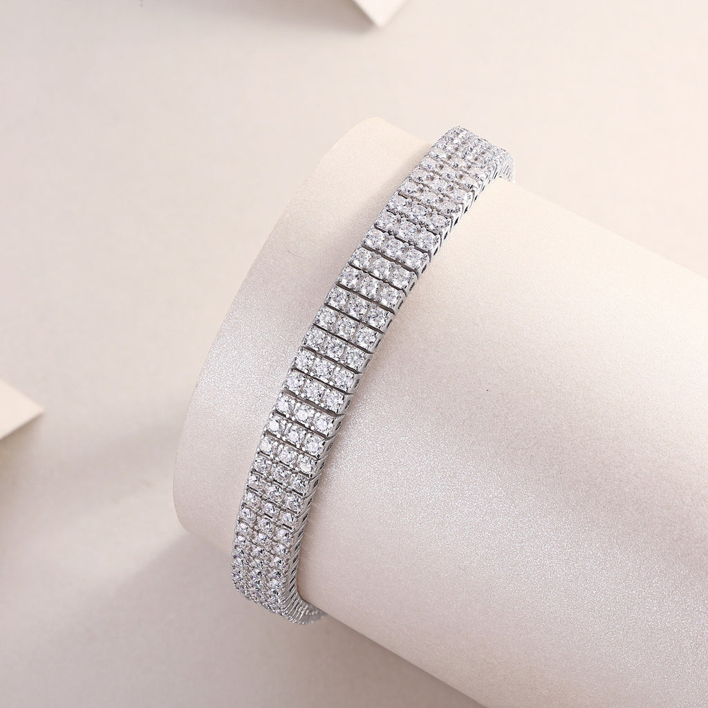 Silver bracelet with clear stones on a light pink background