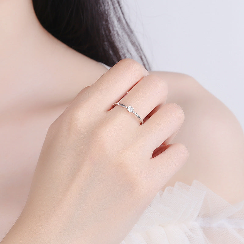 Close-up of a hand wearing a silver ring on a light background