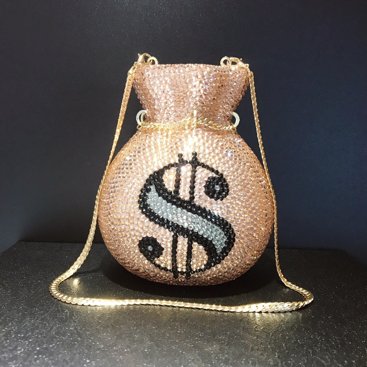 Beaded handbag with dollar sign design on a dark background