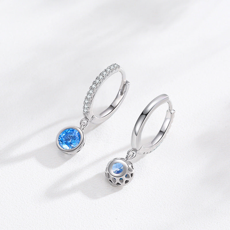 Silver earrings with blue gemstones on a white background