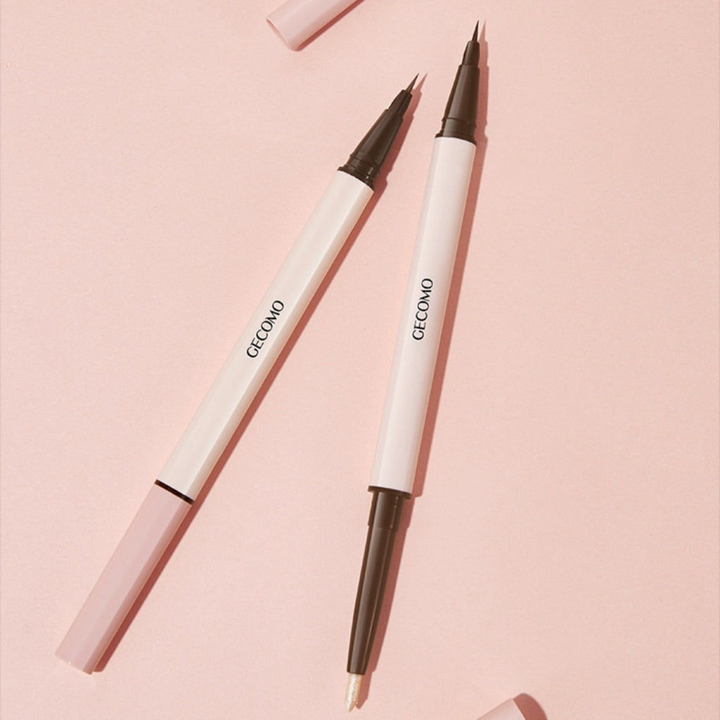 Two white makeup pencils with black tips on a pink background
