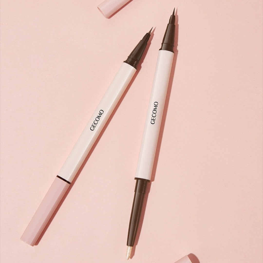Two white makeup pencils with black tips on a pink background