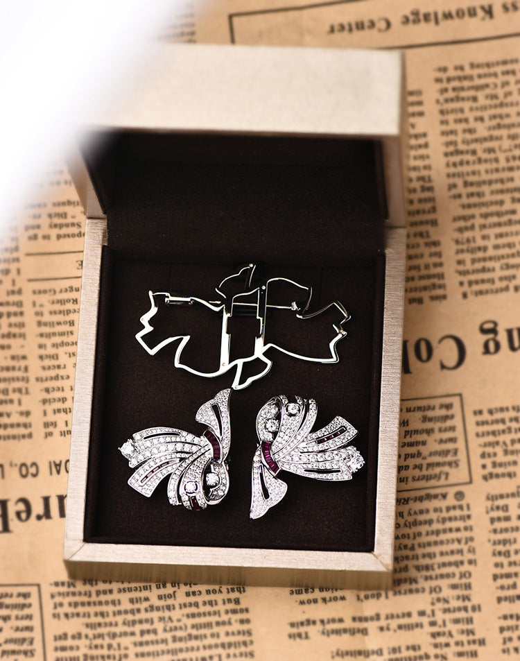 Silver earrings with gemstones in an open jewelry box on a newspaper background
