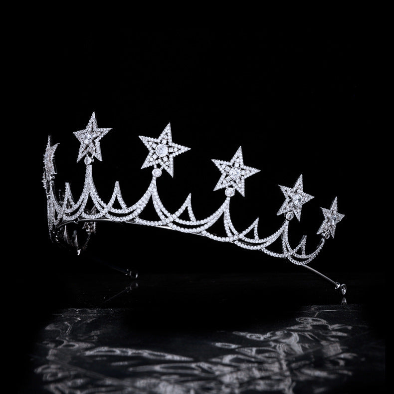 Silver tiara with star-shaped embellishments on a black background