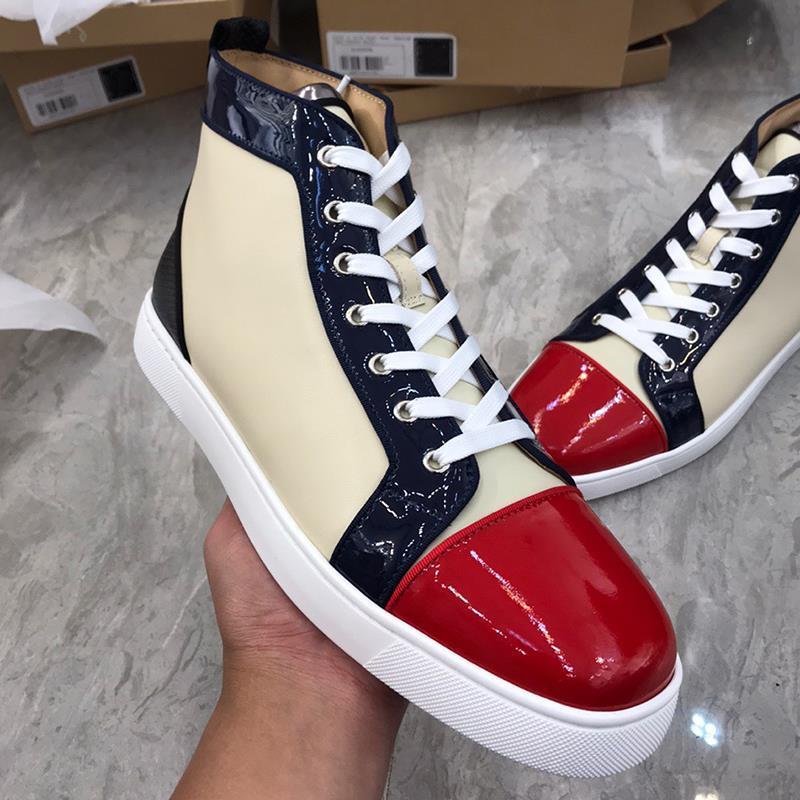 Pair of high-top sneakers with red, white, and navy design held by a hand on a gray surface.