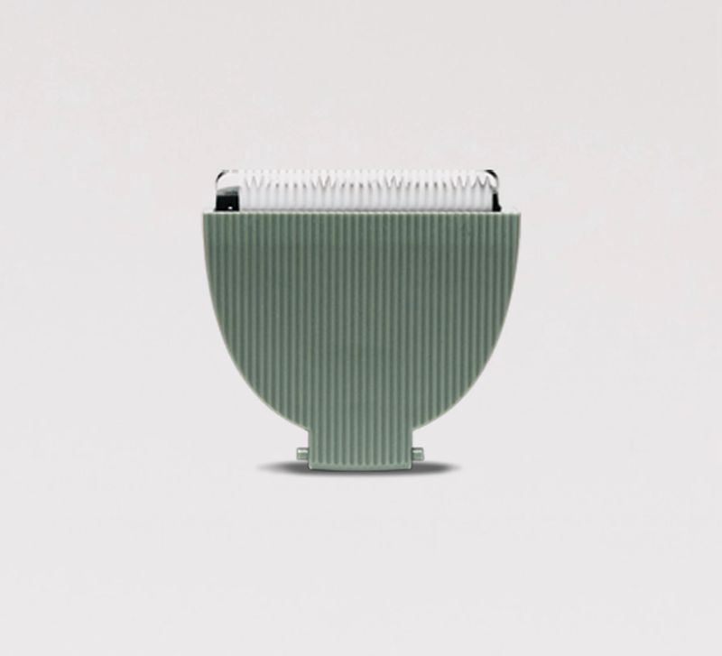 Green textured vase with ribbed design on a light gray background