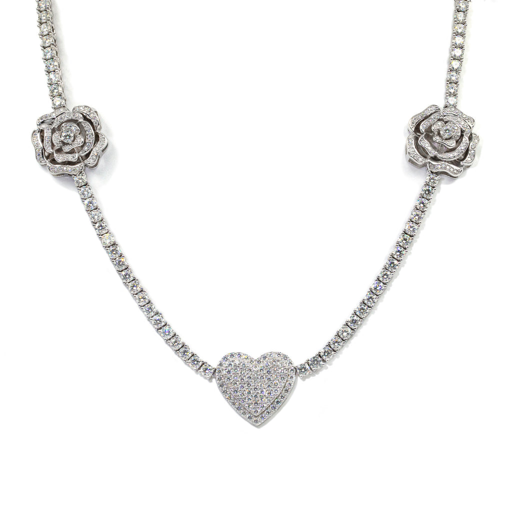 Silver necklace with rose and heart pendants on a white background