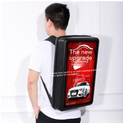 Person wearing a backpack with an Audi advertisement on a white background