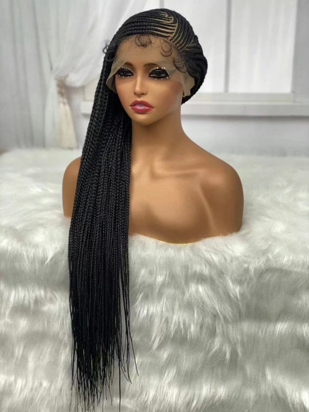 Mannequin head with a long black braided wig on a white background