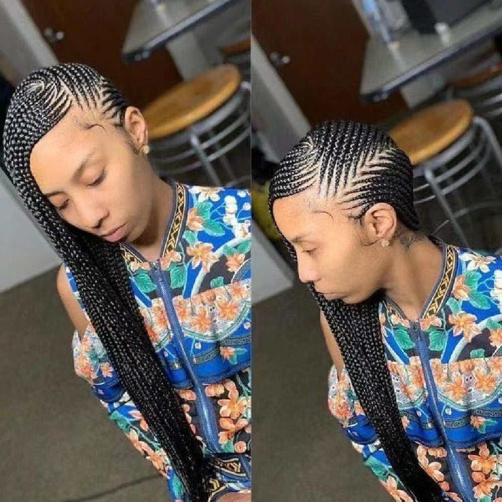 Person with braided hair wearing a colorful top in an indoor setting.
