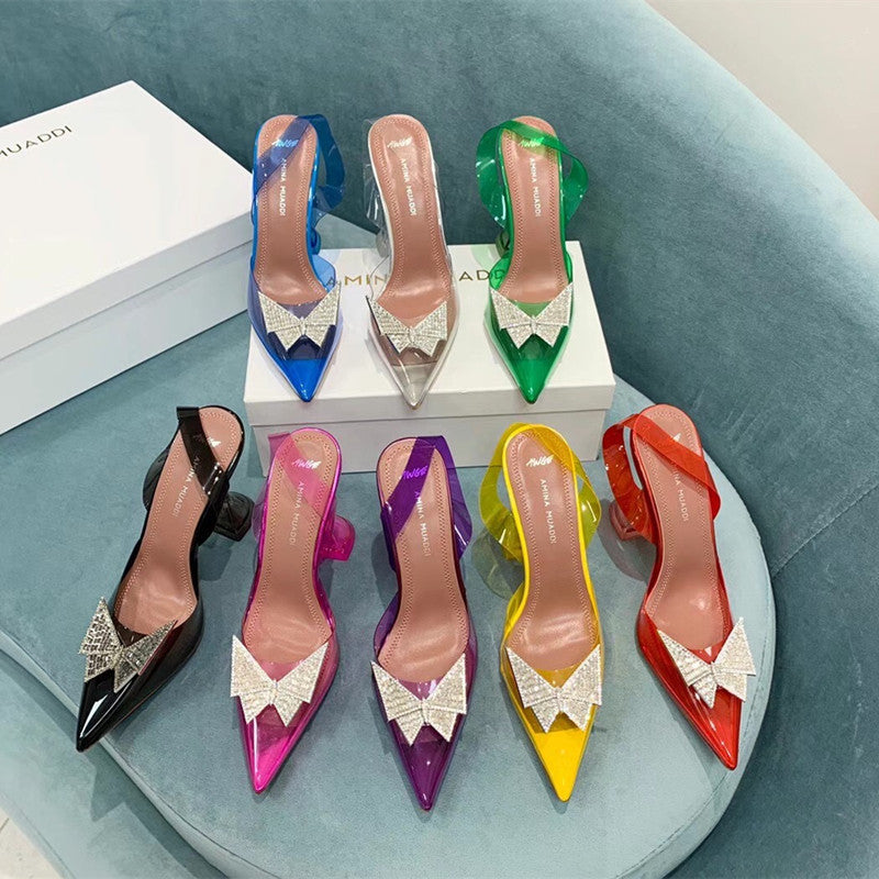 Colorful high-heeled shoes with decorative bows on a light blue surface.
