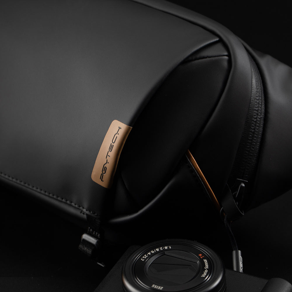 Black backpack with a camera lens on a dark background