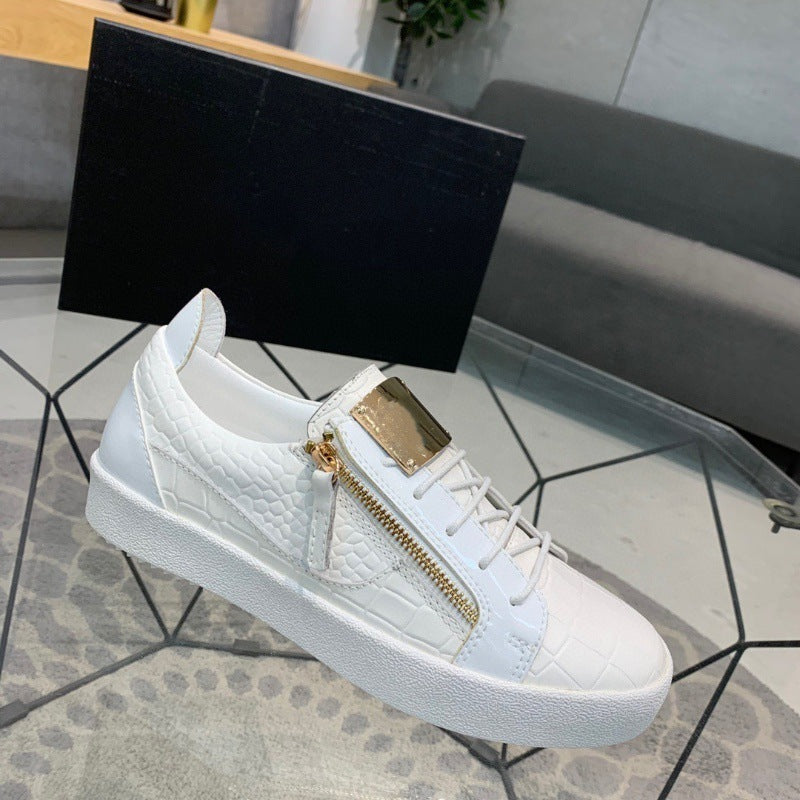 White sneaker with gold zipper on a geometric-patterned surface