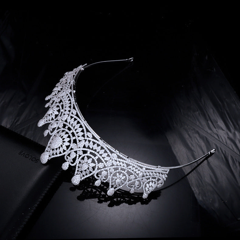 Elegant silver headband with intricate design on a dark background