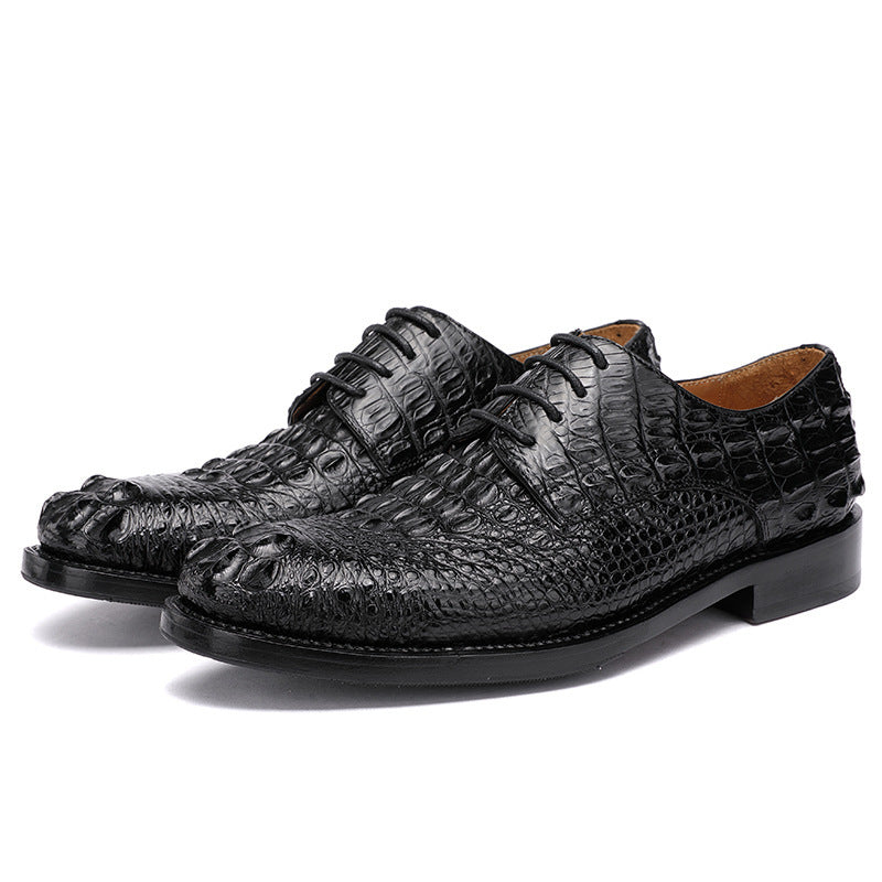 Black crocodile-patterned dress shoes on a white background