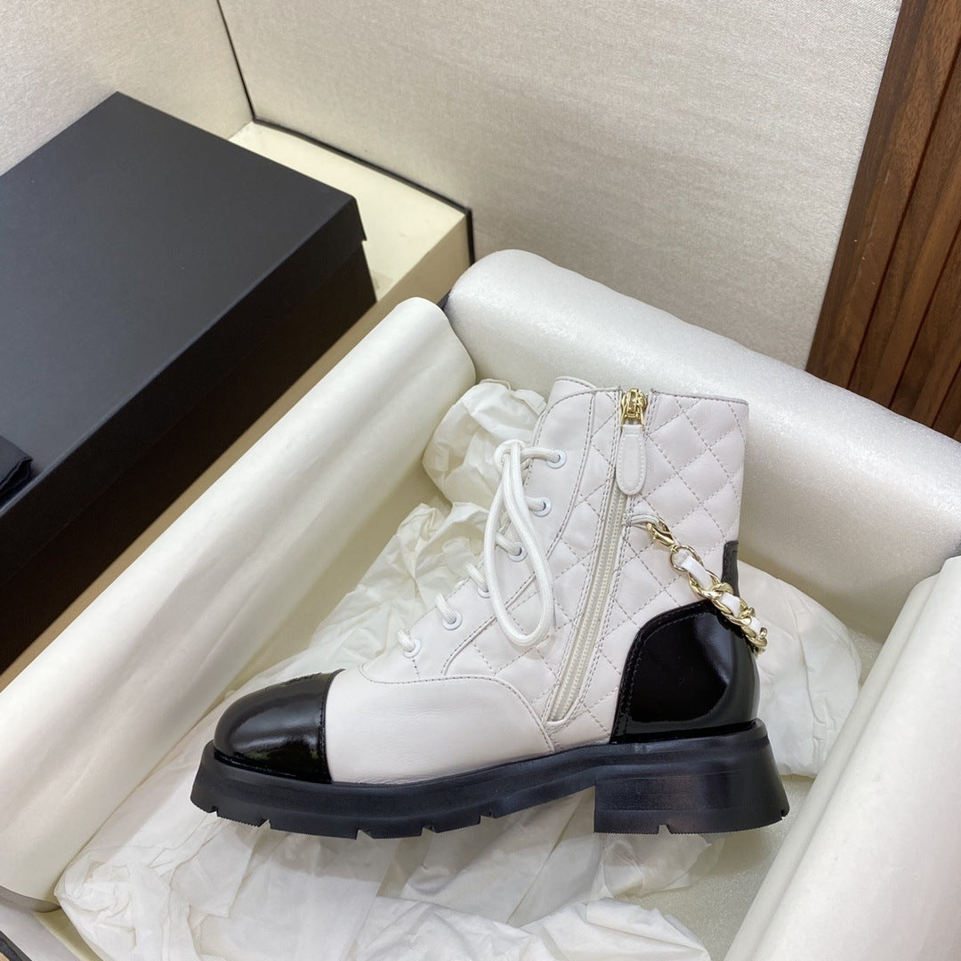 White quilted ankle boot with black sole in a box