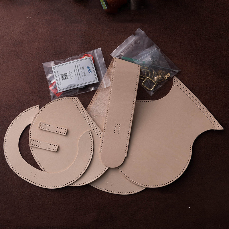 Beige leather shoulder straps on a brown surface with small accessories.