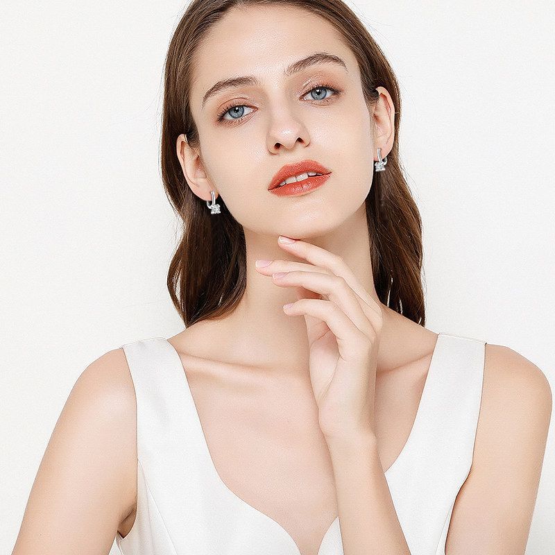 Woman wearing earrings with a plain background