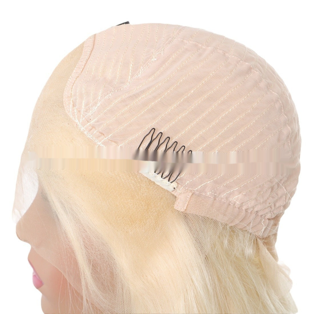 Blonde wig on a mannequin head with a pink cap.