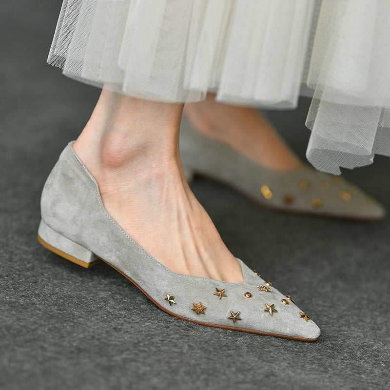 Gray suede flats with star embellishments worn by a person.