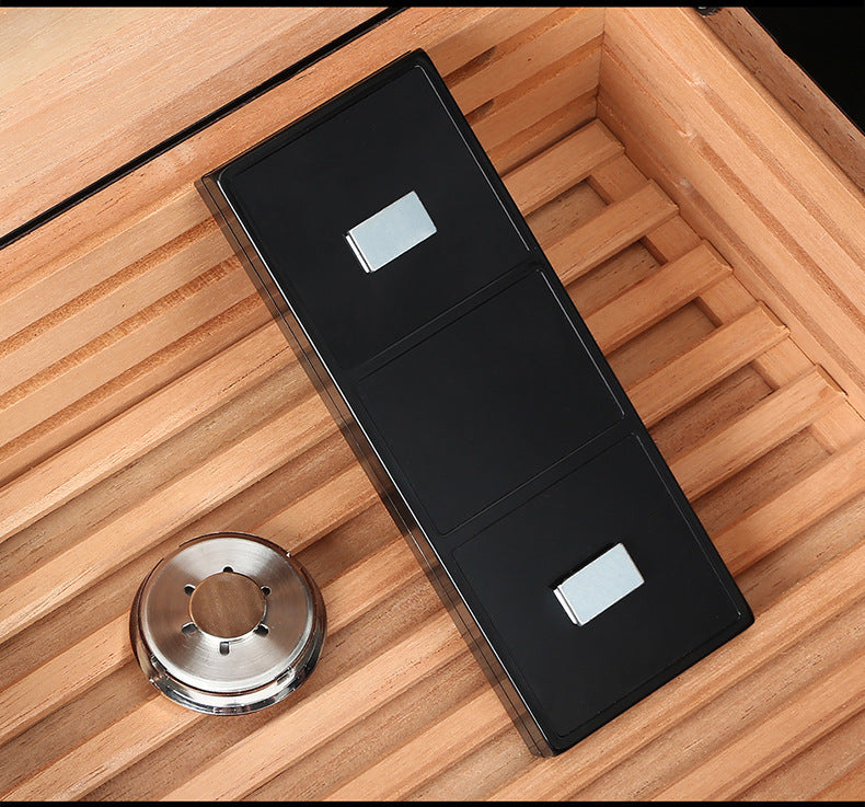 Black rectangular device with two silver buttons on a wooden surface