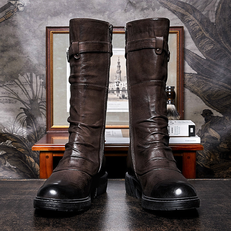 Pair of brown leather boots with black soles on a textured surface.