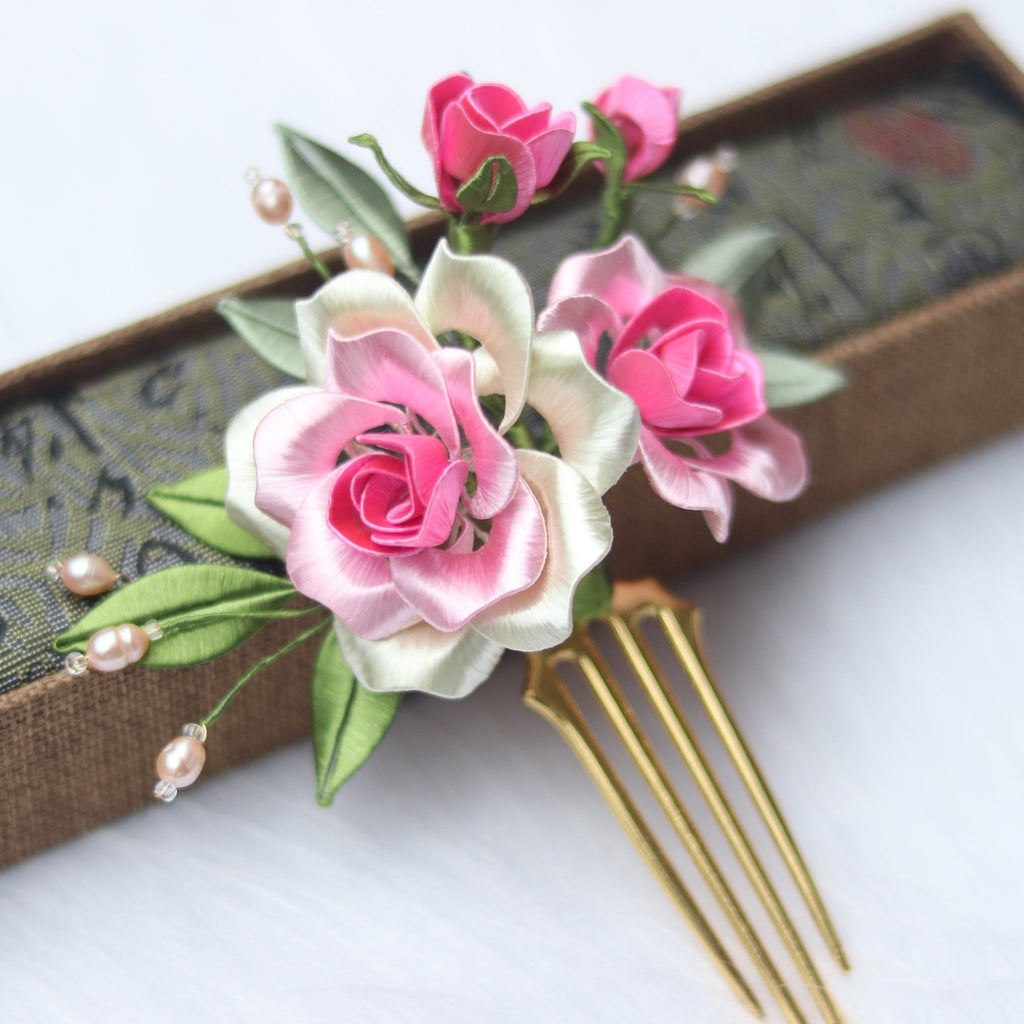 Floral hair comb with pink and white flowers on a white background