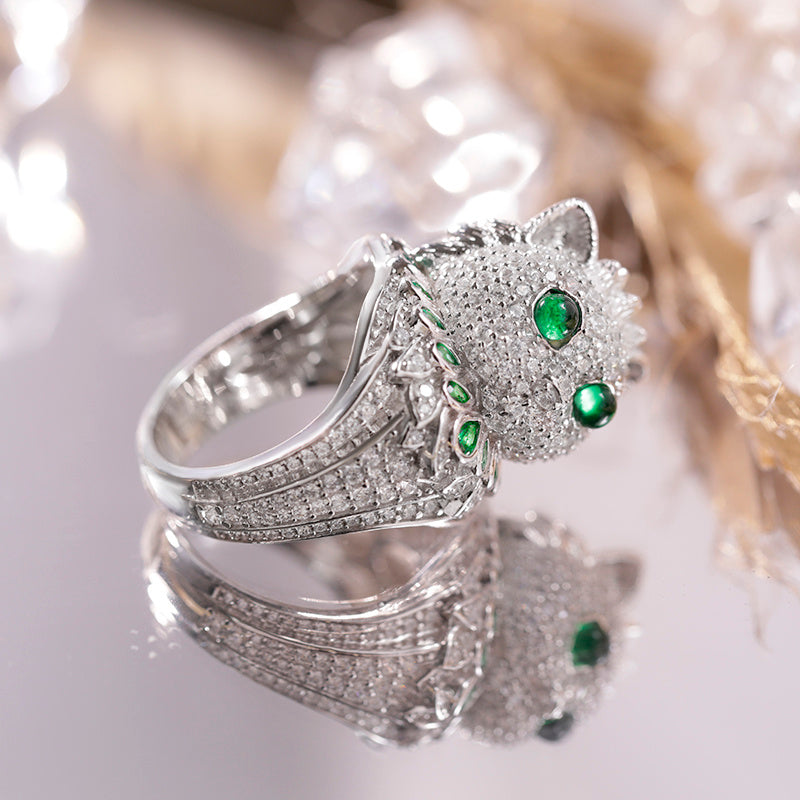 Silver ring with green gemstones on a white background
