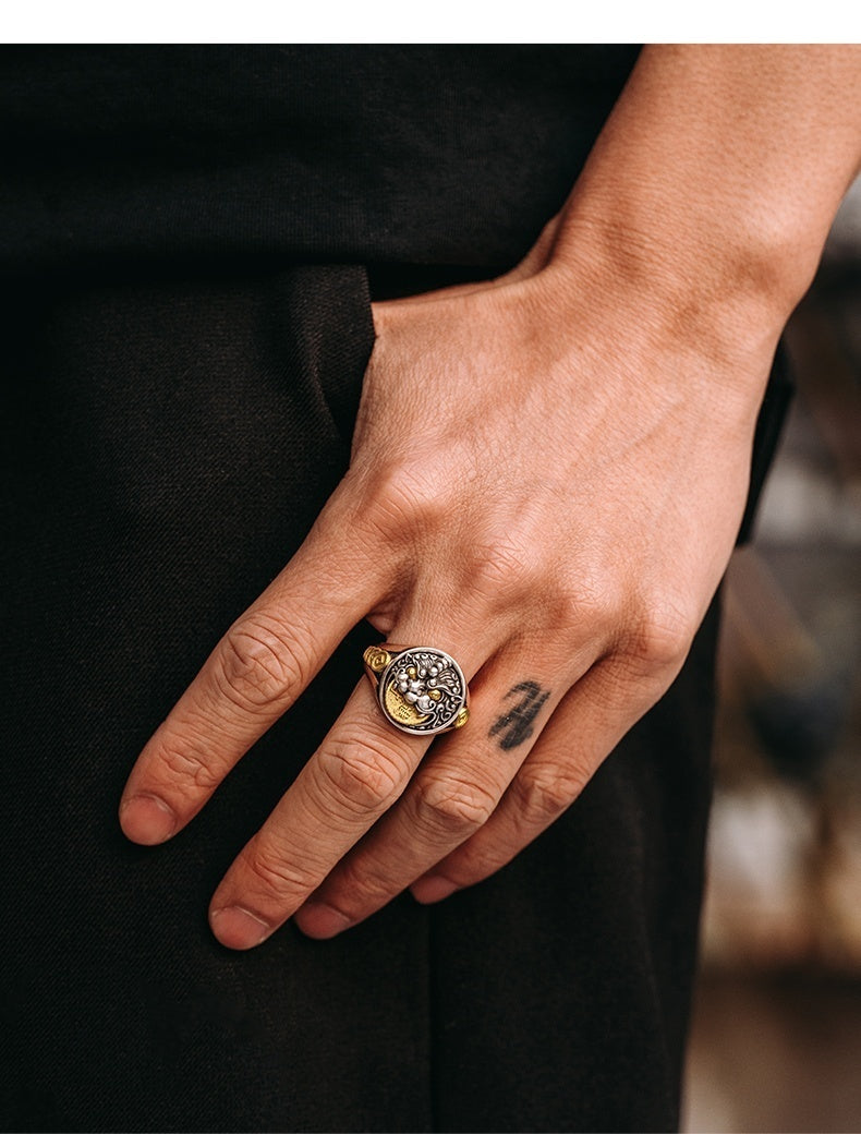 Hand wearing a gold ring with a black background