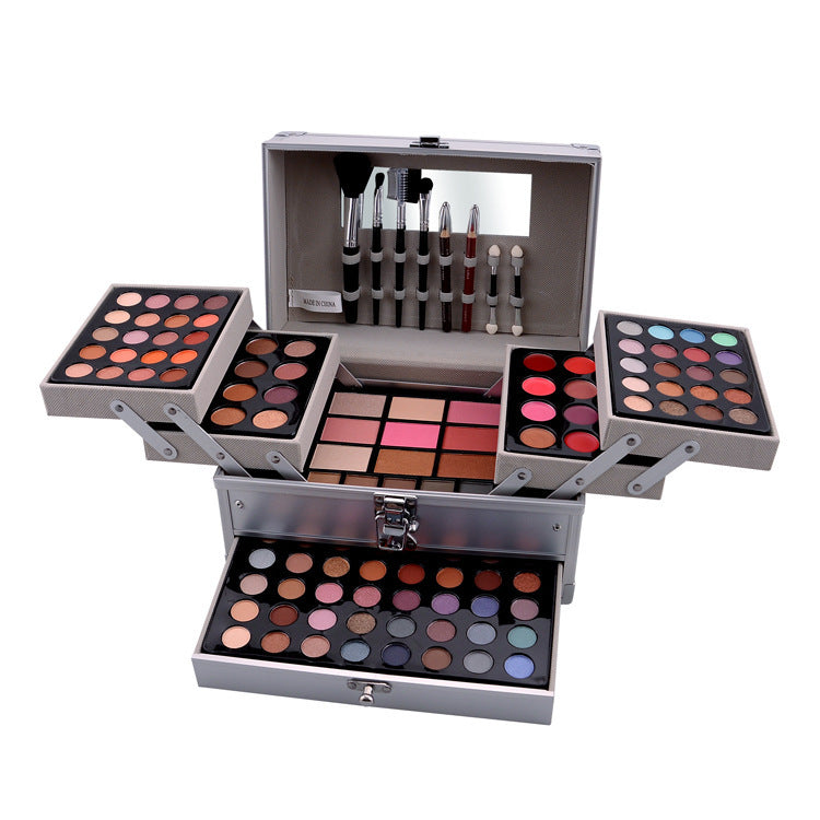 Makeup set with multiple palettes and brushes in a silver case on a white background