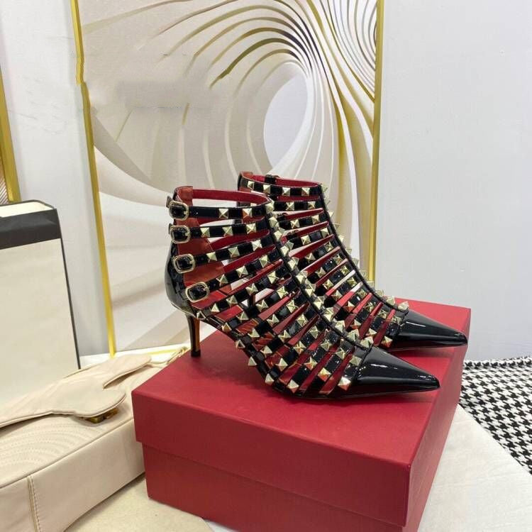 Black studded high-heeled shoes on a red box with a decorative wall in the background