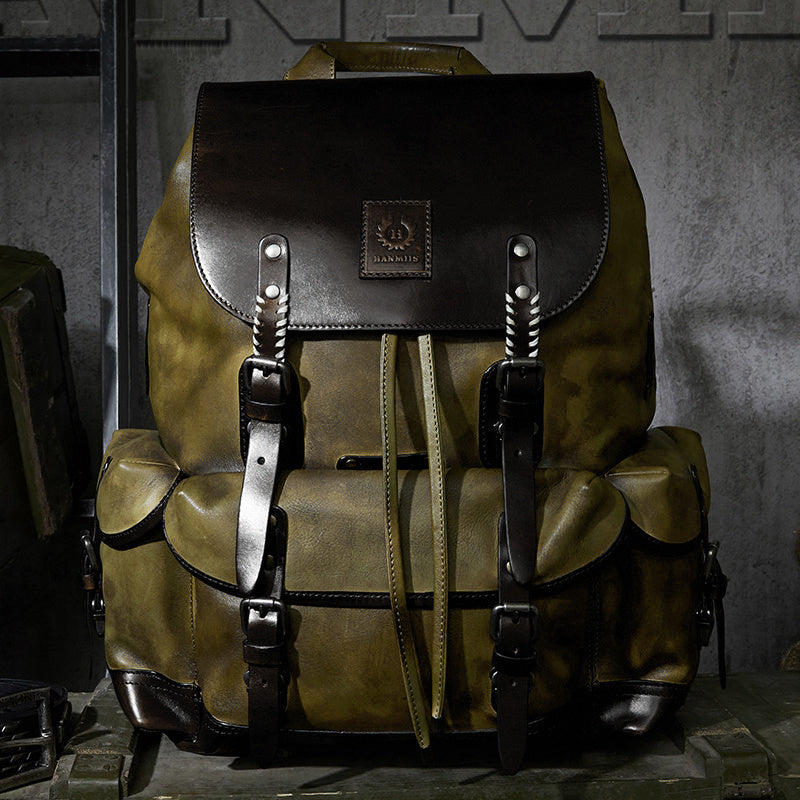 Brown leather backpack with black straps on a textured surface