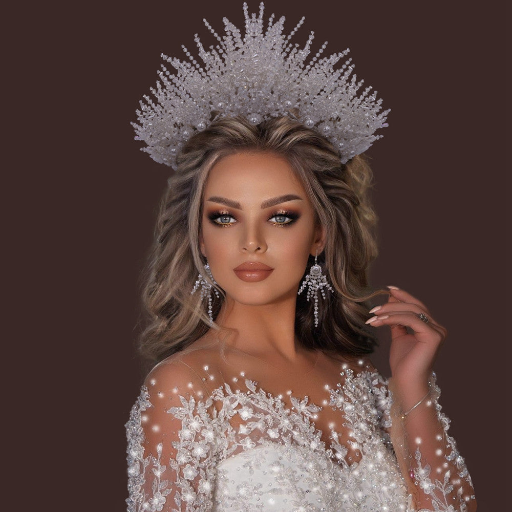 Woman wearing a sparkling silver tiara and dress on a dark background