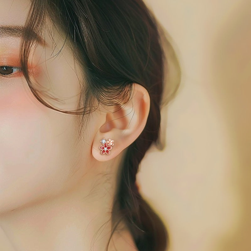 Close-up of an ear wearing a floral earring with a blurred background
