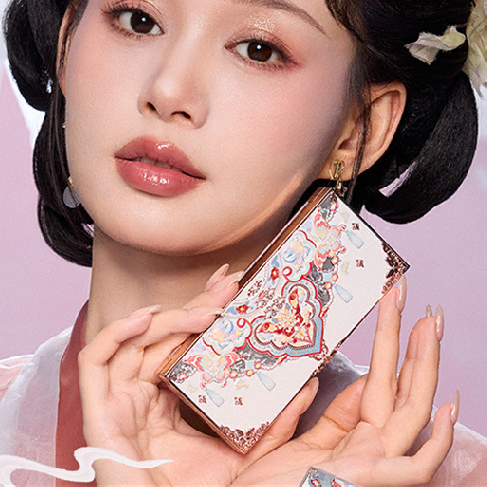 Woman holding a decorative makeup box with intricate designs on a pink background
