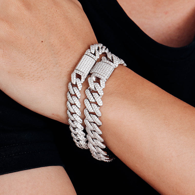 Silver chain bracelet on a wrist with a black background